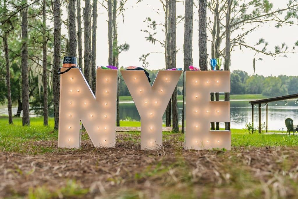 Marquee letters that spell NYE with party favors on top