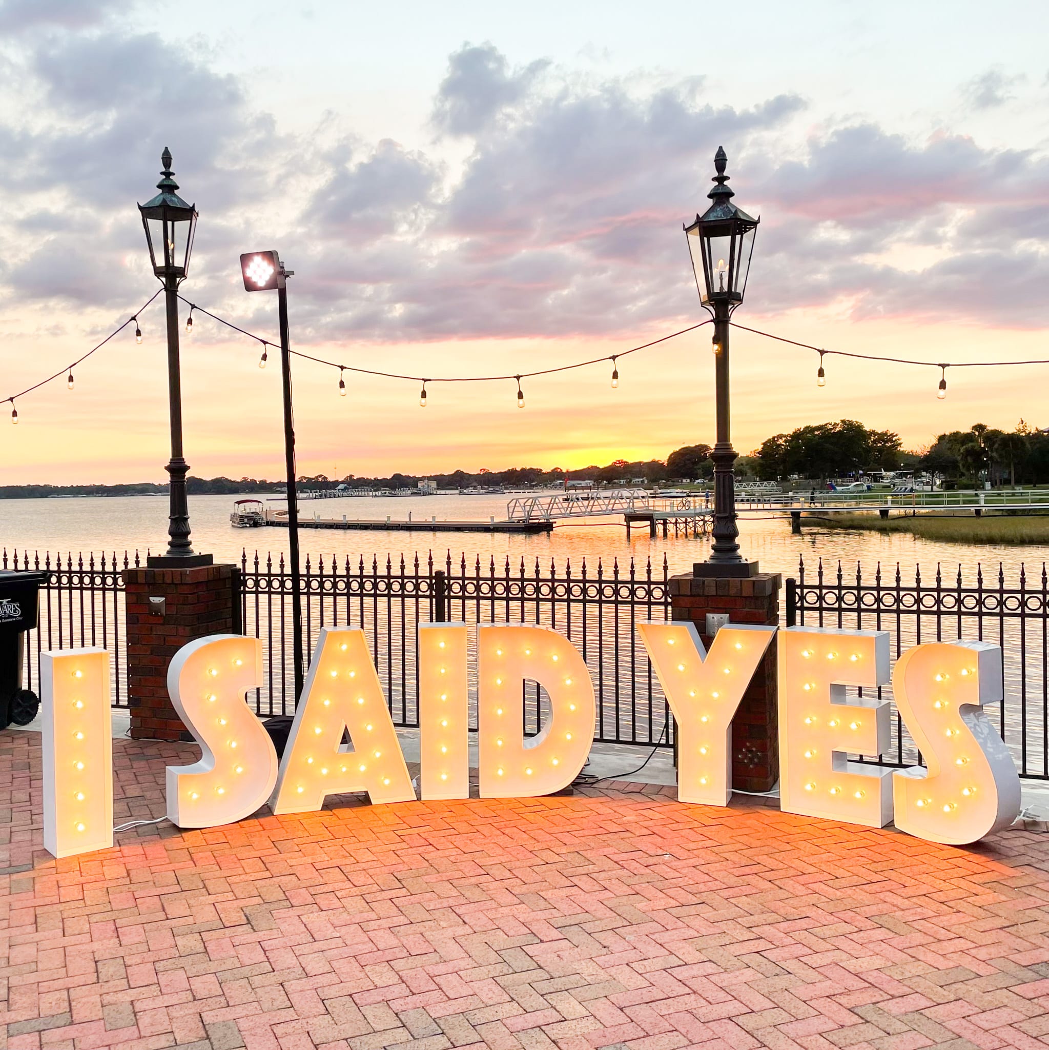 Marquee letters set up on a pier that read "I SAID YES"