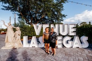 Women at a corporate event with marquee letters that spell ‘Venue Las Vegas’