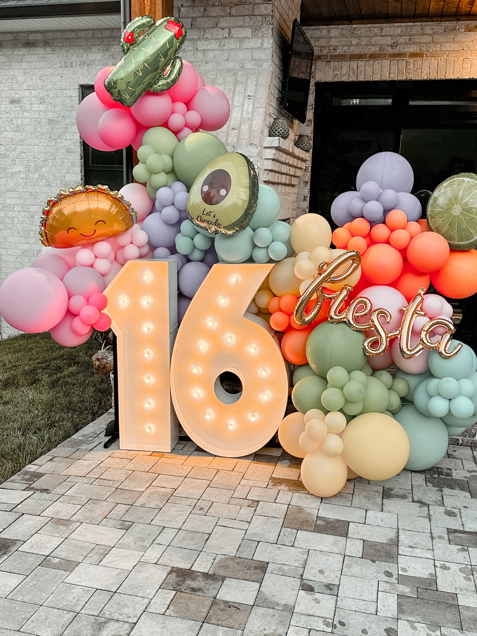 Light Up Numbers "16" beside a balloon display for a Sweet 16 party