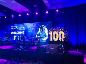 Stage at a conference with an Astronaut on the LED screen and light up numbers that read '100'