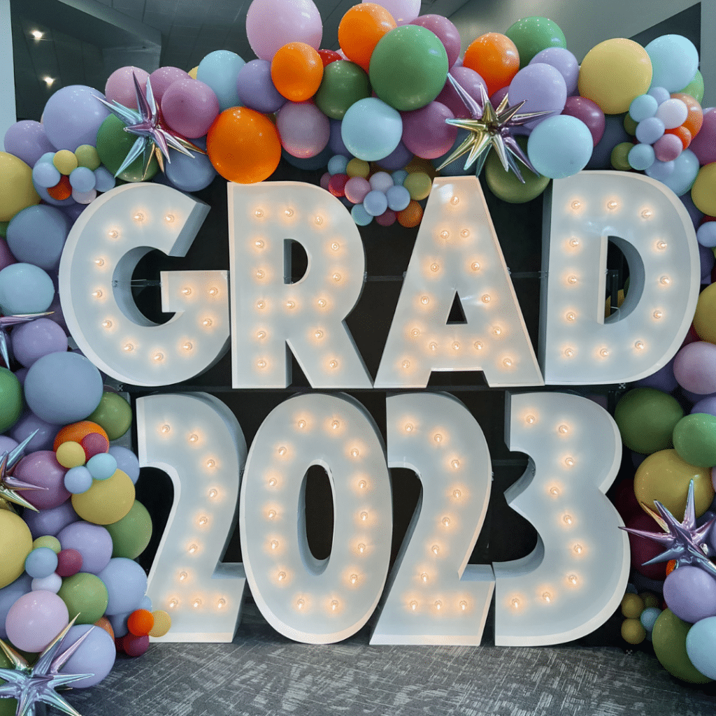 Marquee Light Up Letters with balloon display stacked to spell out "GRAD" on the top level and "2023" on the lower level