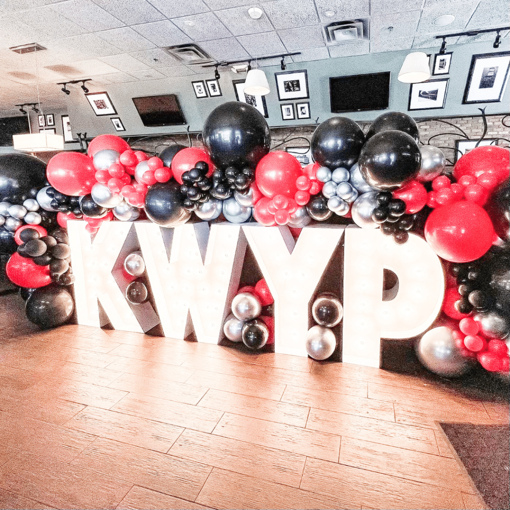 Light-Up Marquee Letters spelling out KWYP with balloon display