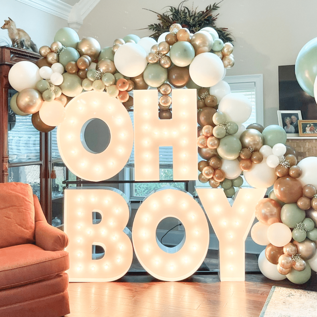 Oh Boy spelled out for baby shower with gold, green, and white balloons